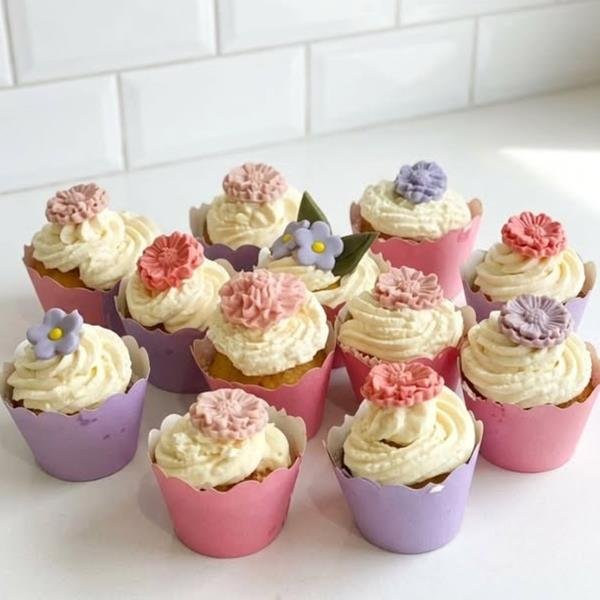 Cupcakes com chantilly e flores de açúcar em tons de rosa e lilás